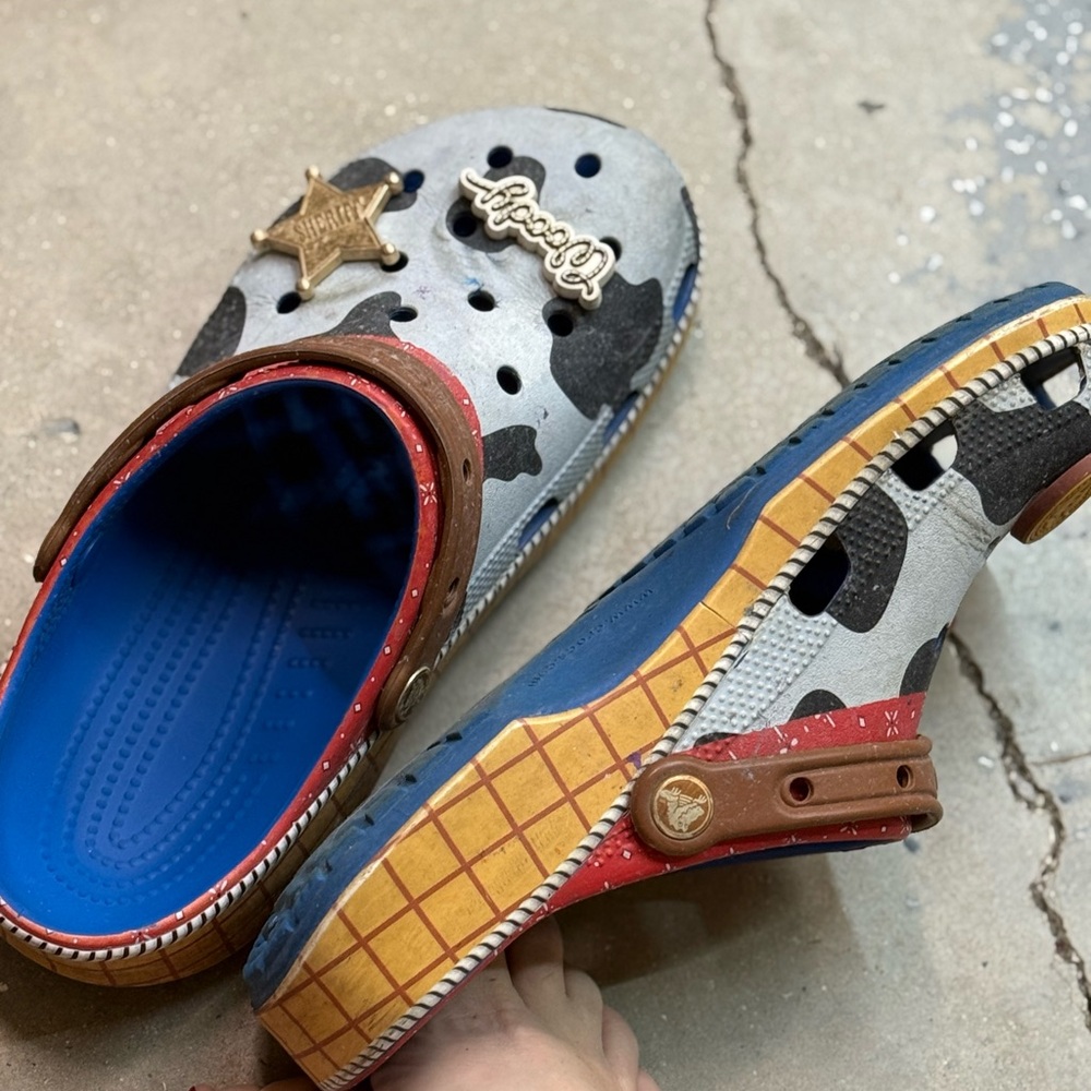 Well worn CROCS Multicolor Flats with Cow Print and Badge